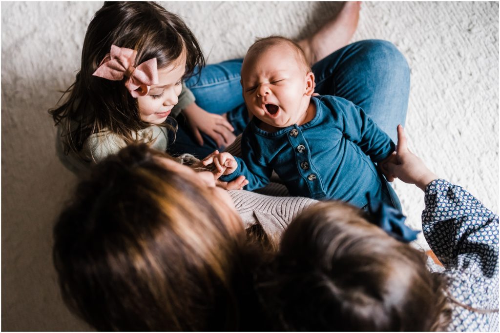 overhead angle of newborn with siblings, lifestyle newborn photos