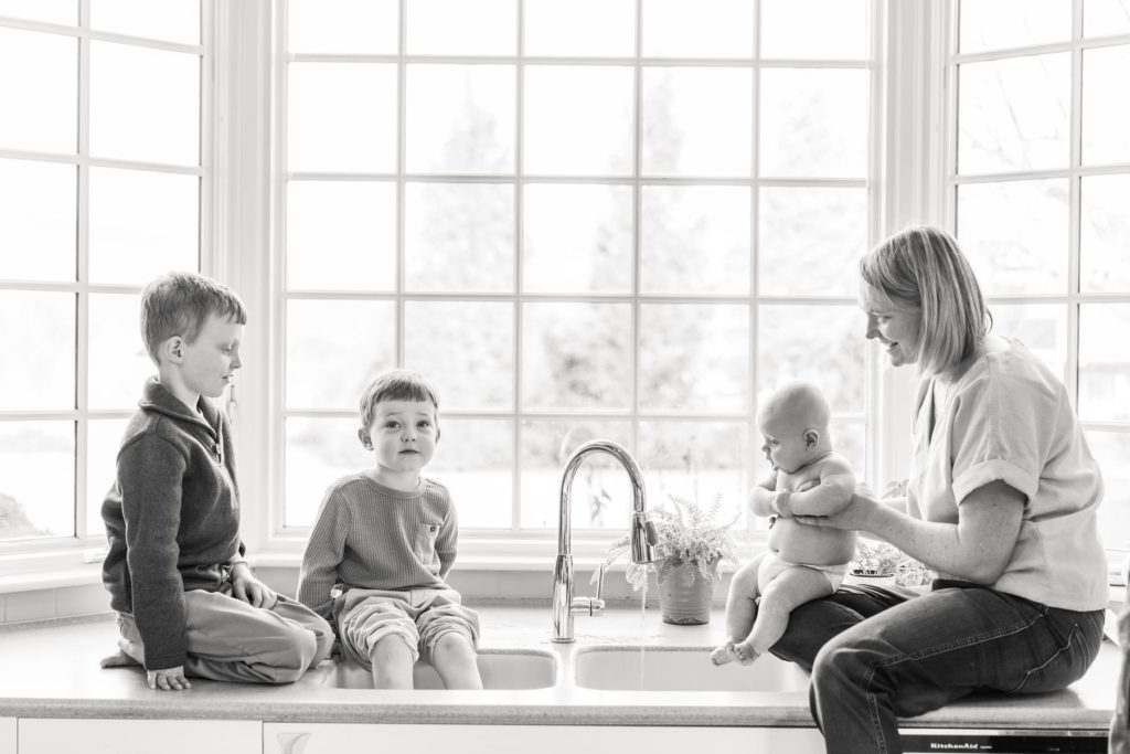 newborn photos with 2 siblings in kitchen sink